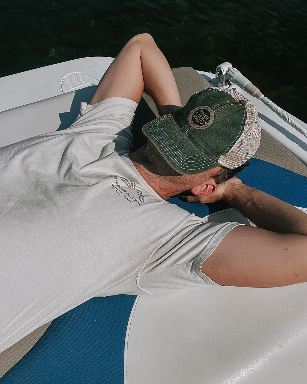 Nor'easter Apparel dad hat in green with Take er Easy slogan on man taking a nap