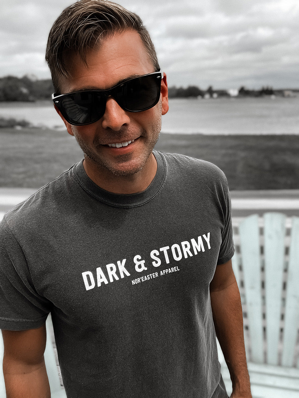 Nor'easter Apparel Dark and Stormy cocktail graphic tee front view on a man smiling wearing sunglasses