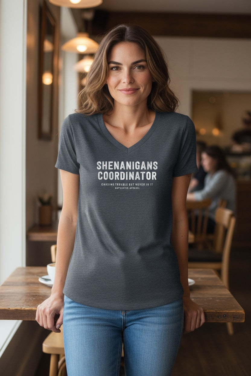 Woman wearing a t-shirt with 'SHENANIGANS COORDINATOR' text in a casual setting.