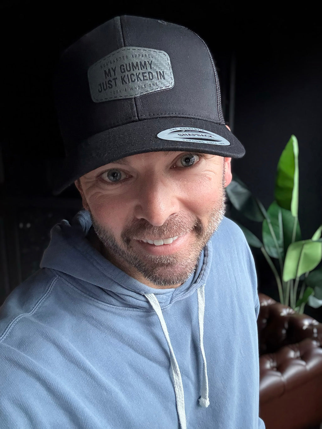 Gummy kicked in hat, black hat with grey patch on a man