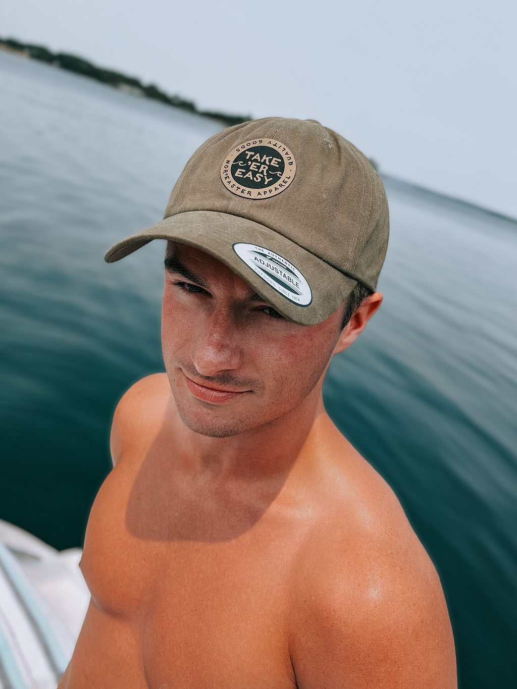 man on a boat wearing a take er easy hat in green, front view