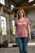 woman in a t-shirt standing in a warehouse for pitty's sake