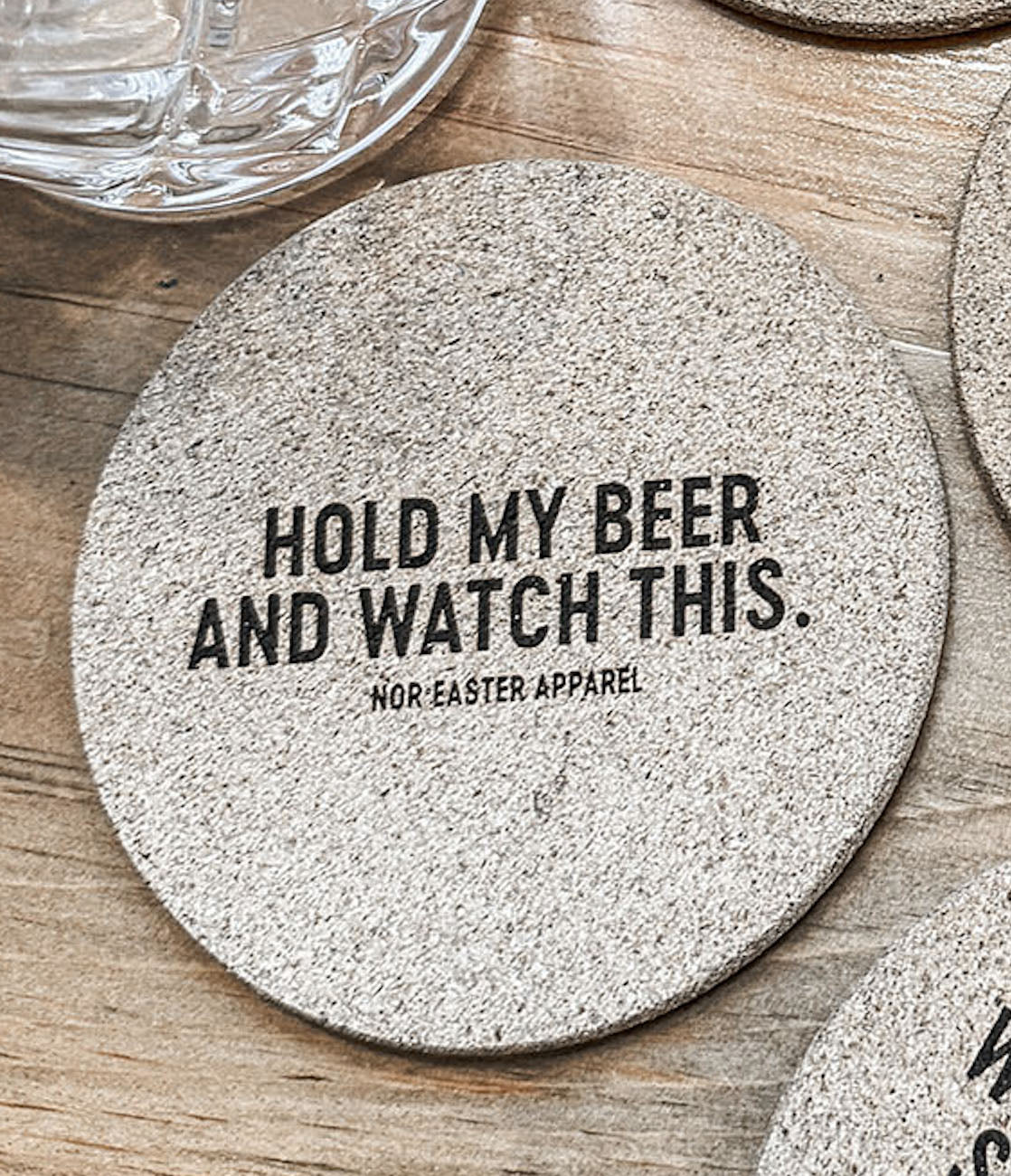 Round stone coaster with text on a wooden surface