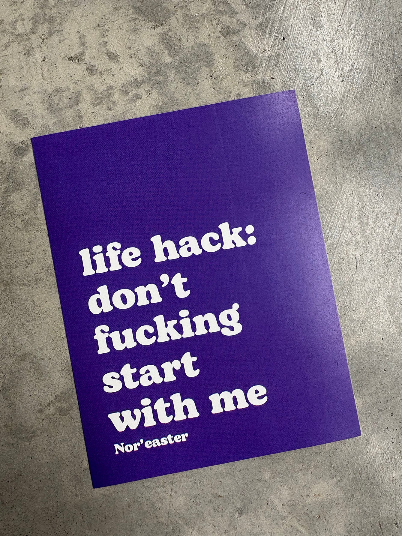 Purple poster with white text on a gray surface