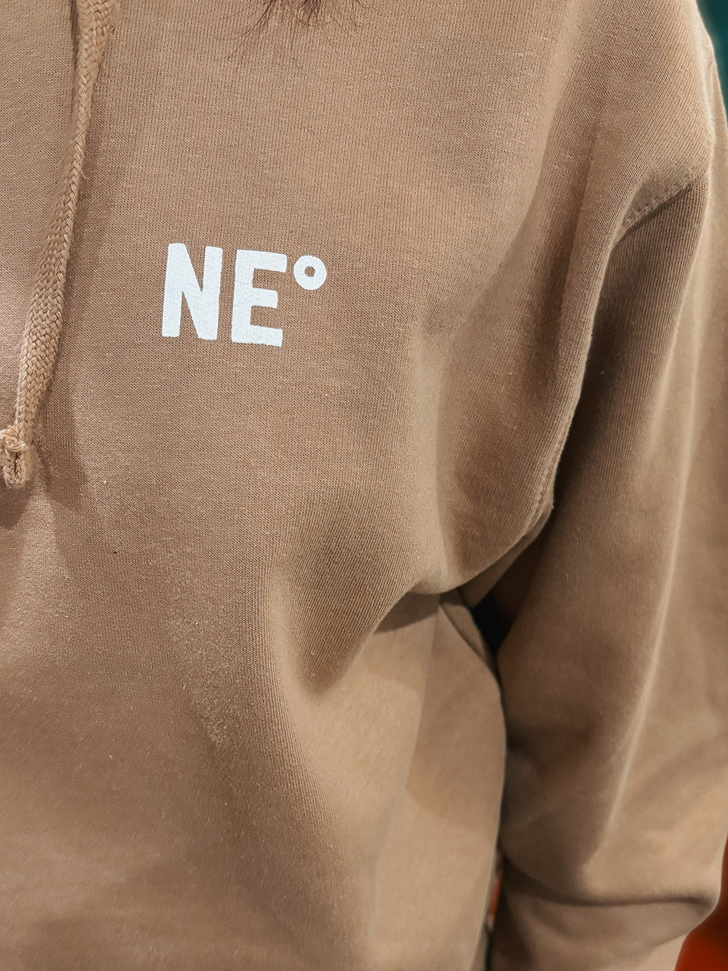 Nor'easter Apparel sandstone hoodie with white monogram, detail view