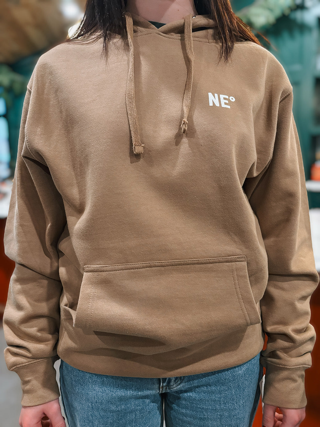 Nor'easter Apparel sandstone hoodie with white monogram on a young girl, front view