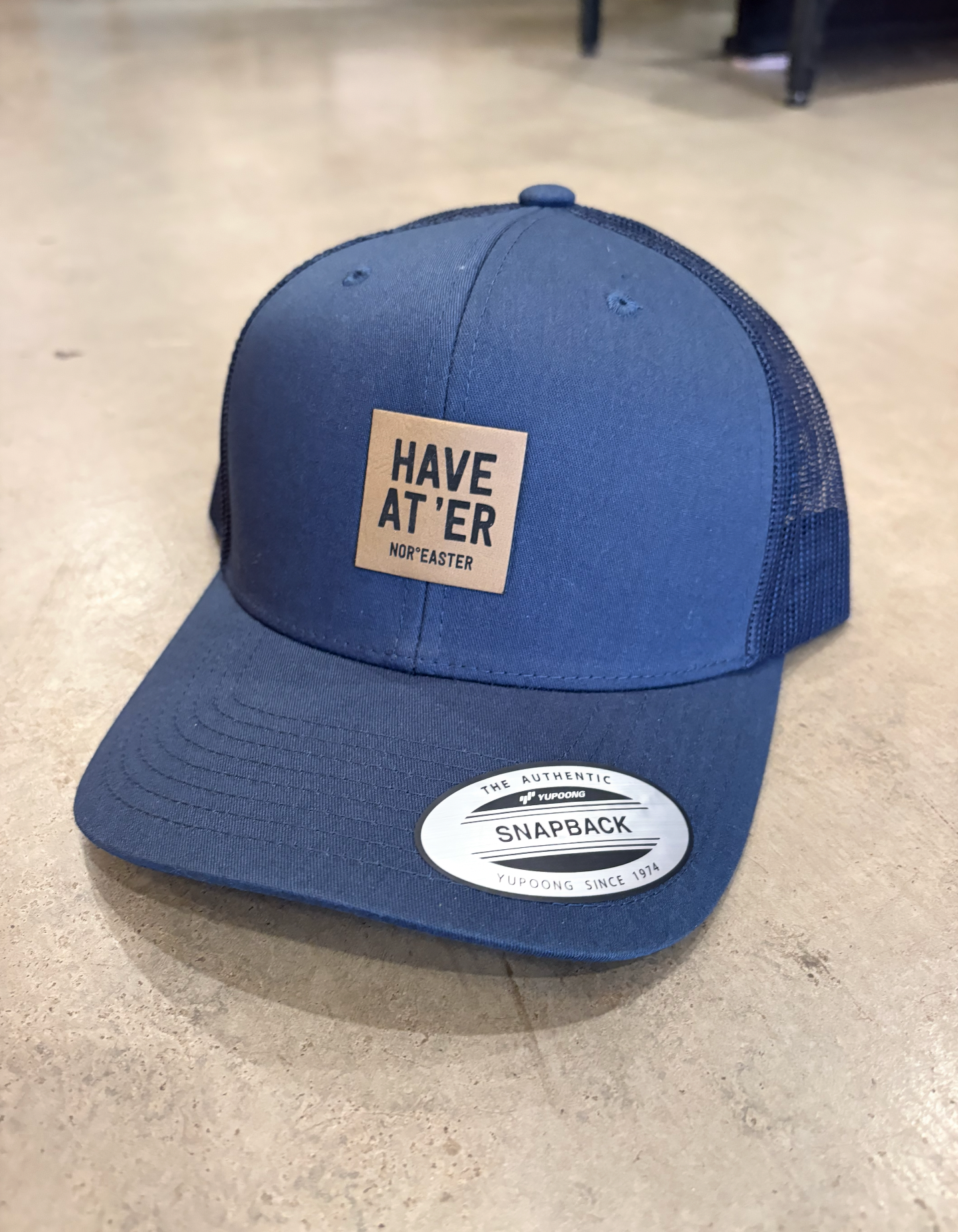 navy have at'er hat on a concrete floor. 