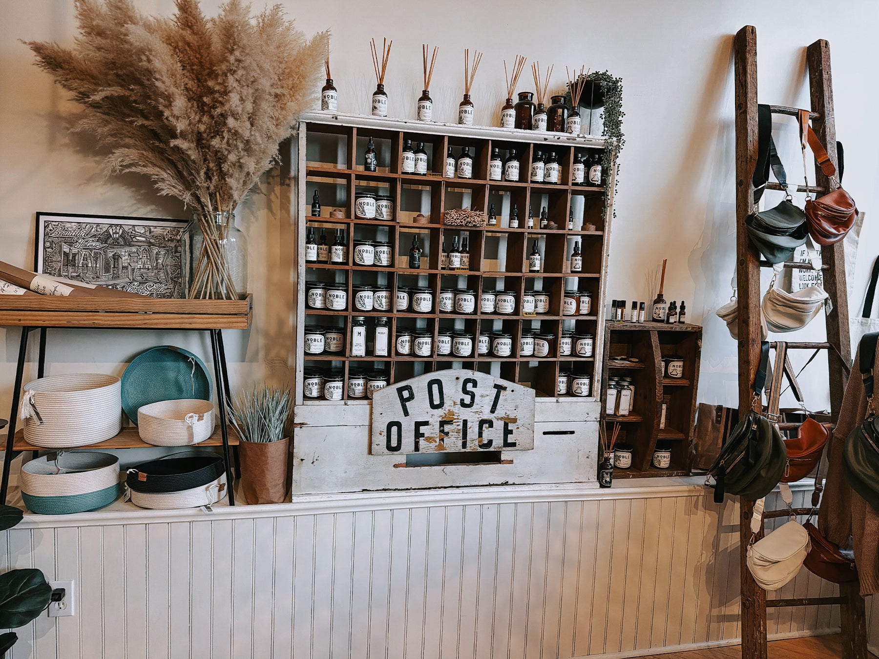 mercantile on duke with decorative interior with shelves, plants, and a 'Post Office' sign.